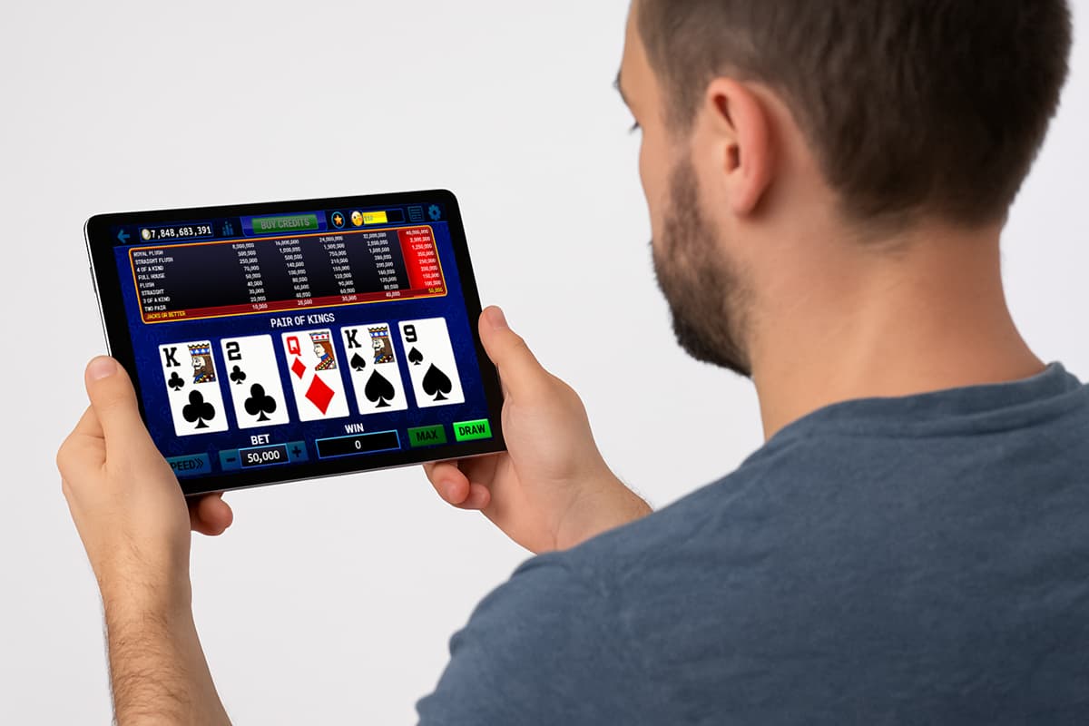 a man plays online Jacks or Better on his tablet